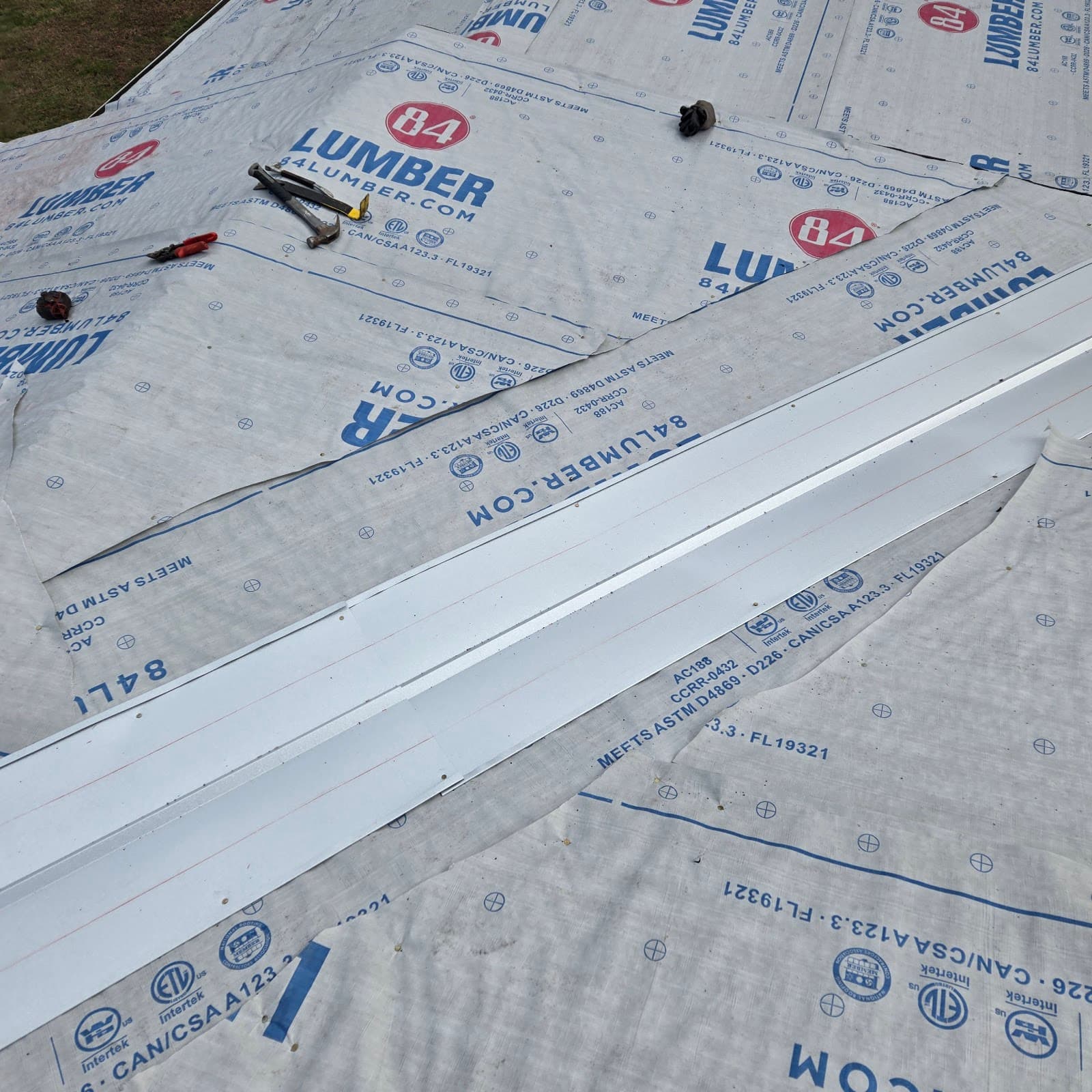 Roof decking covered in protective synthetic underlayment during prep