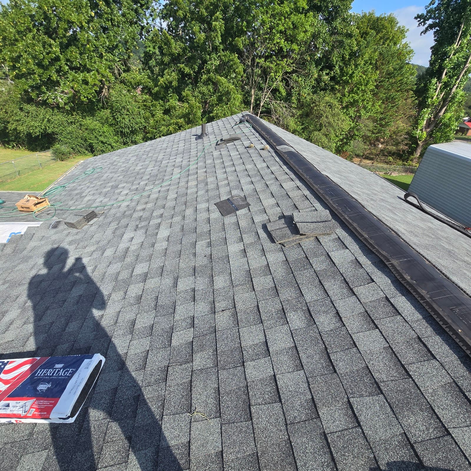 New grey architectural shingle roof with ridge vent installed